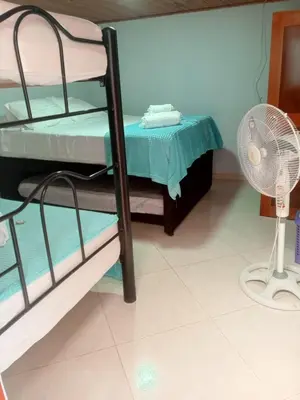 a room with two bunk beds and a fan at Hotel El Balcon de madera in Norcasia