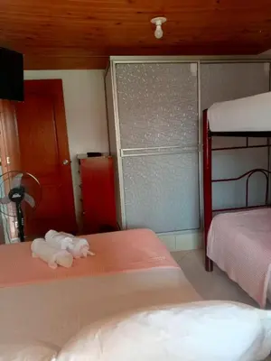 a bedroom with two beds with a stuffed animal on the floor at Hotel El Balcon de madera in Norcasia