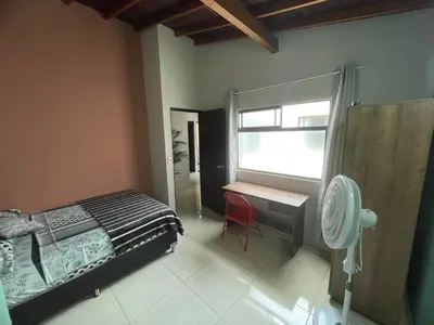 a bedroom with a bed and a desk and a window at Apartamento Relax in Medellín