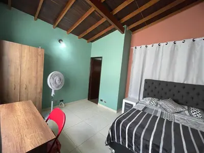 a bedroom with a bed and a table with a fan at Apartamento Relax in Medellín