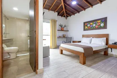 a bedroom with a bed and a shower and a bathroom at Hotel Prada in Bello
