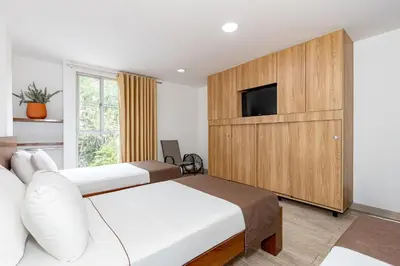 a hotel room with two beds and a tv at Hotel Prada in Bello