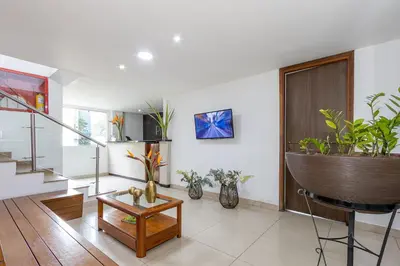a living room with a staircase and some plants at Hotel Prada in Bello