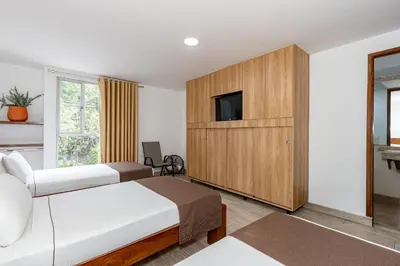 a hotel room with two beds and a tv at Hotel Prada in Bello
