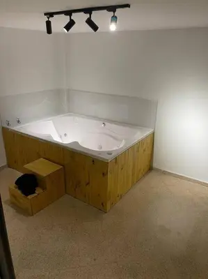 a large bath tub with a black cat sitting in it at Cozy house en envigado con Jacuzzi in Envigado