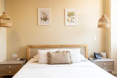 a bedroom with a large white bed with two night stands at Mythical Hotel Boutique in Medellín