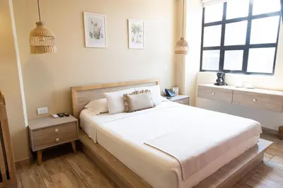 a bedroom with a large white bed and a window at Mythical Hotel Boutique in Medellín