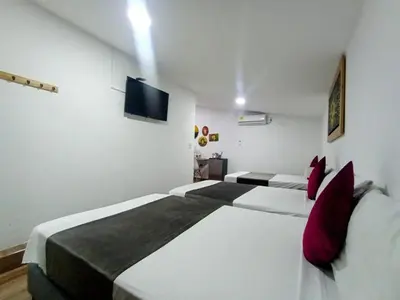 a bedroom with two beds and a flat screen tv at Aguacatala Hotel Boutique in Medellín