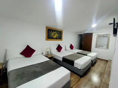 two beds in a hotel room with red pillows at Aguacatala Hotel Boutique in Medellín
