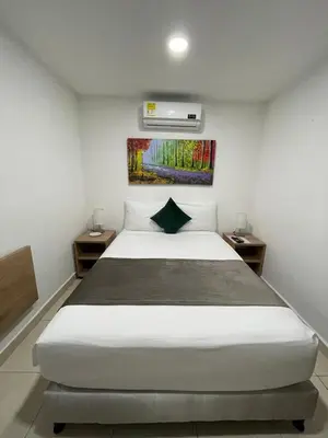a bedroom with a large white bed in a room at Aguacatala Hotel Boutique in Medellín