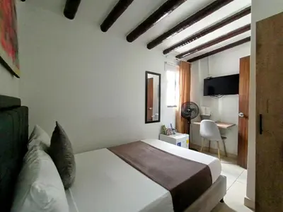a hotel room with a bed and a desk at Aguacatala Hotel Boutique in Medellín