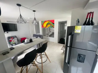 a kitchen with a refrigerator and a table and chairs at Duplex By Hope in Guatapé