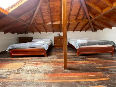 two beds in a room with wooden ceilings at Duplex By Hope in Guatapé