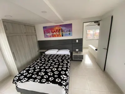 a bedroom with a bed with a black and white blanket at Duplex By Hope in Guatapé