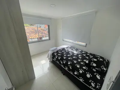 a small bedroom with a bed and a window at Duplex By Hope in Guatapé