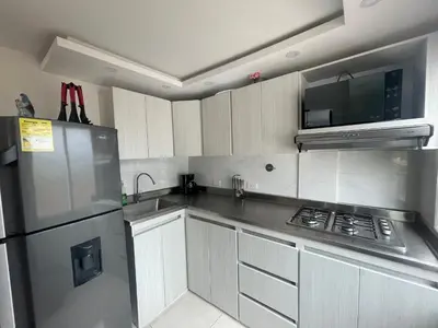 a kitchen with a stainless steel refrigerator and a microwave at Duplex By Hope in Guatapé