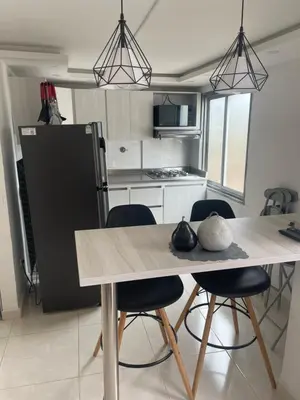 a kitchen with a table and chairs and a refrigerator at Duplex By Hope in Guatapé