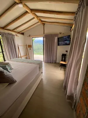 a bedroom with a bed and a large window at Montecafé Jardín in Jardin