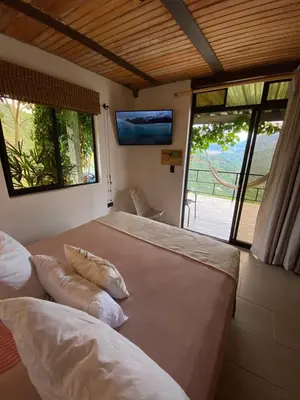 a bedroom with two beds and a tv on the wall at Montecafé Jardín in Jardin