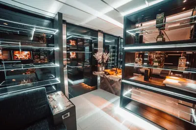 a bar with glass shelves with alcohol bottles at 1Million Luxury Suites in Medellín