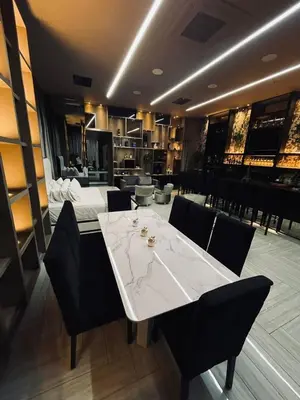 a dining room with a white table and black chairs at 1Million Luxury Suites in Medellín