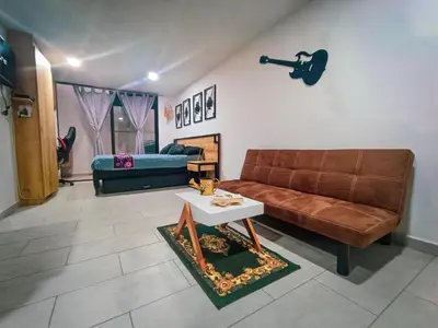 a living room with a couch and a table at Acogedor loft frente al tranvía in Medellín