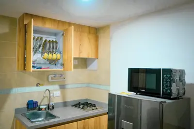 a small kitchen with a sink and a microwave at Acogedor loft frente al tranvía in Medellín