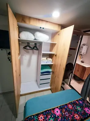 a room with a bed and a room with a closet at Acogedor loft frente al tranvía in Medellín
