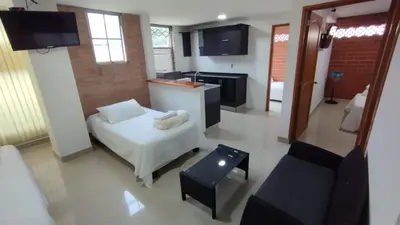 a living room with a white couch and a kitchen at LIVING Montes in Medellín
