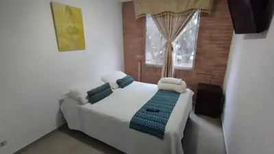 a bedroom with a white bed and a window at LIVING Montes in Medellín
