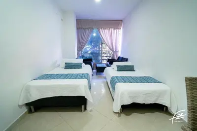 a room with three beds and a window at LIVING Montes in Medellín