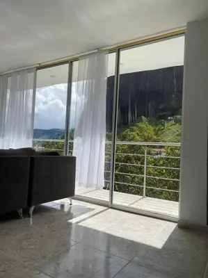 a living room with a large glass window at Linda casa con espectacular vista embalse y piedra in Guatapé