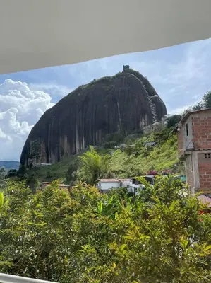 a large mountain in the distance with a building at Linda casa con espectacular vista embalse y piedra in Guatapé