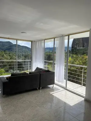 a living room with a couch in front of windows at Linda casa con espectacular vista embalse y piedra in Guatapé
