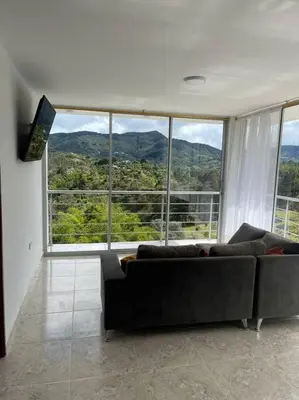 a living room with a couch in front of a large window at Linda casa con espectacular vista embalse y piedra in Guatapé