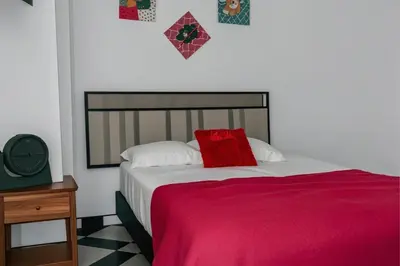 a bedroom with a bed with a red pillow on it at Aparta Suite Torre De Prado 302 in Medellín