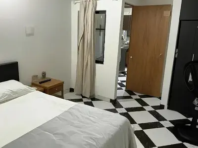 a bedroom with a bed and a checkered floor at Aparta Suite Torre De Prado 302 in Medellín