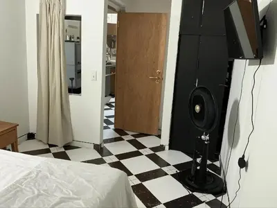 a bedroom with a room with a checkerboard floor at Aparta Suite Torre De Prado 302 in Medellín