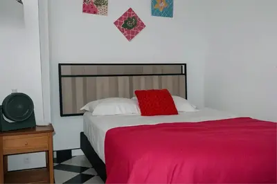 a bedroom with a bed with a red pillow on it at Aparta Suite Torre De Prado 302 in Medellín