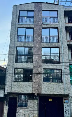 a tall brick building with many windows at Aparta Suite Torre De Prado 302 in Medellín