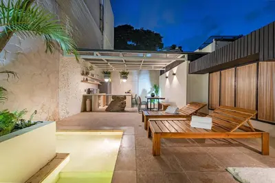 a patio with wooden benches on a building at Provenza 6 Bedroom House by HOUSY HOST in Medellín