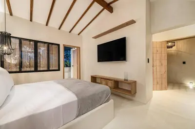 a bedroom with a large bed and a flat screen tv at Provenza 6 Bedroom House by HOUSY HOST in Medellín