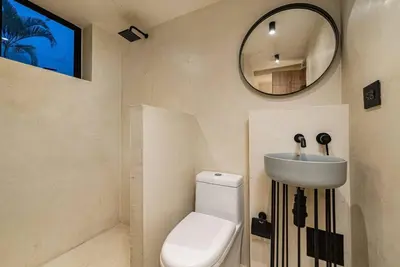 a bathroom with a toilet and a sink and a mirror at Provenza 6 Bedroom House by HOUSY HOST in Medellín