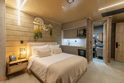 a bedroom with a large bed and a kitchen at Hotel Living by Armoniko in Medellín