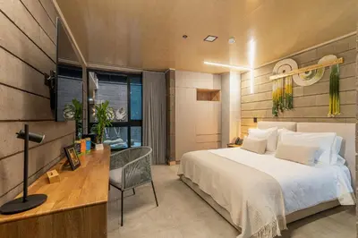 a bedroom with a bed and a desk with a chair at Hotel Living by Armoniko in Medellín