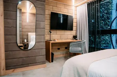 a bedroom with a desk and a tv on a wall at Hotel Living by Armoniko in Medellín
