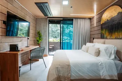 a bedroom with a bed and a desk and a window at Hotel Living by Armoniko in Medellín