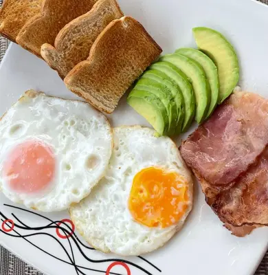 a plate of breakfast foods with eggs ham and toast at CoLinkHouse Hotel in Medellín