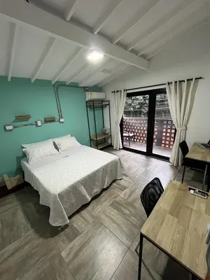 a bedroom with a white bed and a large window at CoLinkHouse Hotel in Medellín