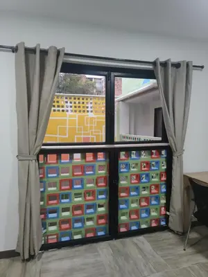 a room with a sliding glass door with curtains at CoLinkHouse Hotel in Medellín